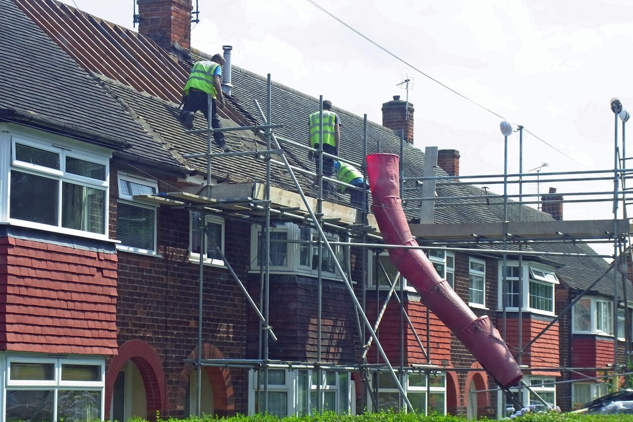 Roofers re-roofing a row of UK terraced houses